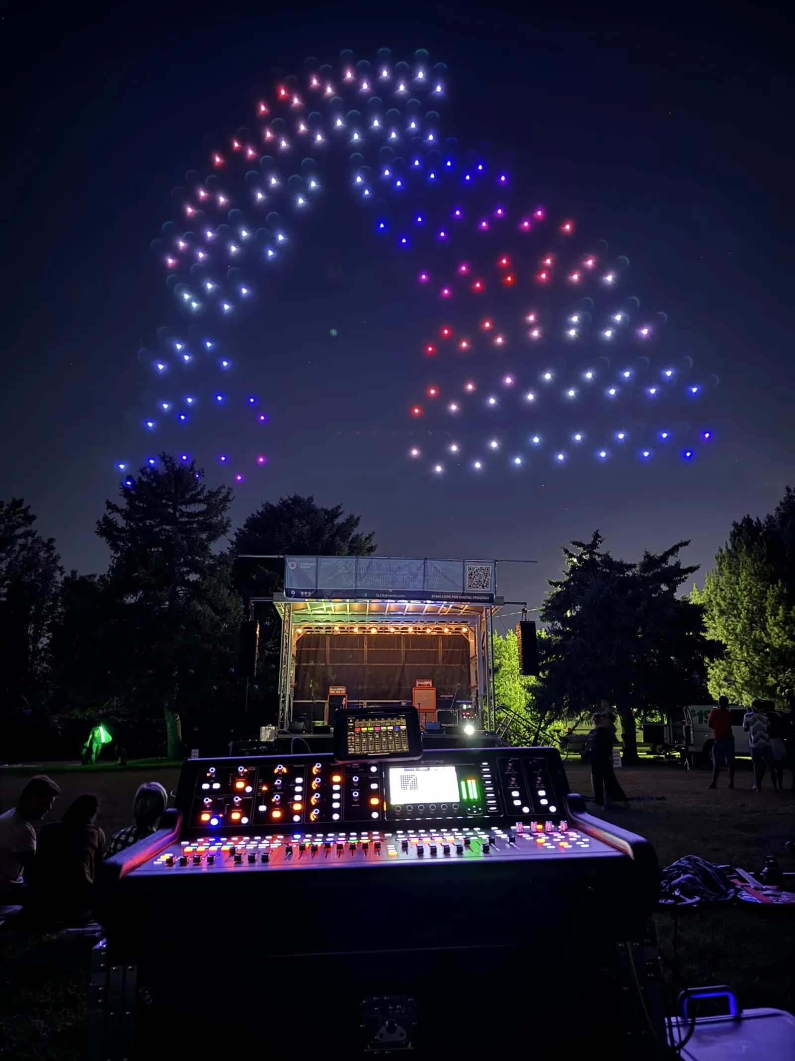 Drone light show above an outdoor stage