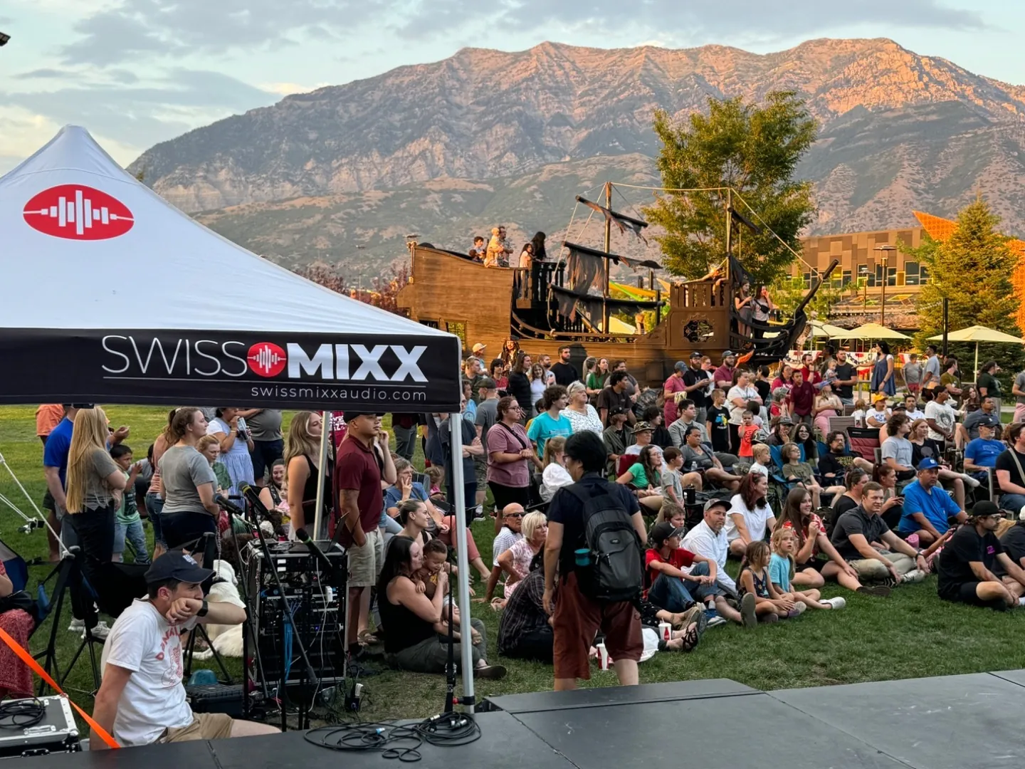 Outdoor event crowd beneath the Utah mountains with SwissMixx production tent