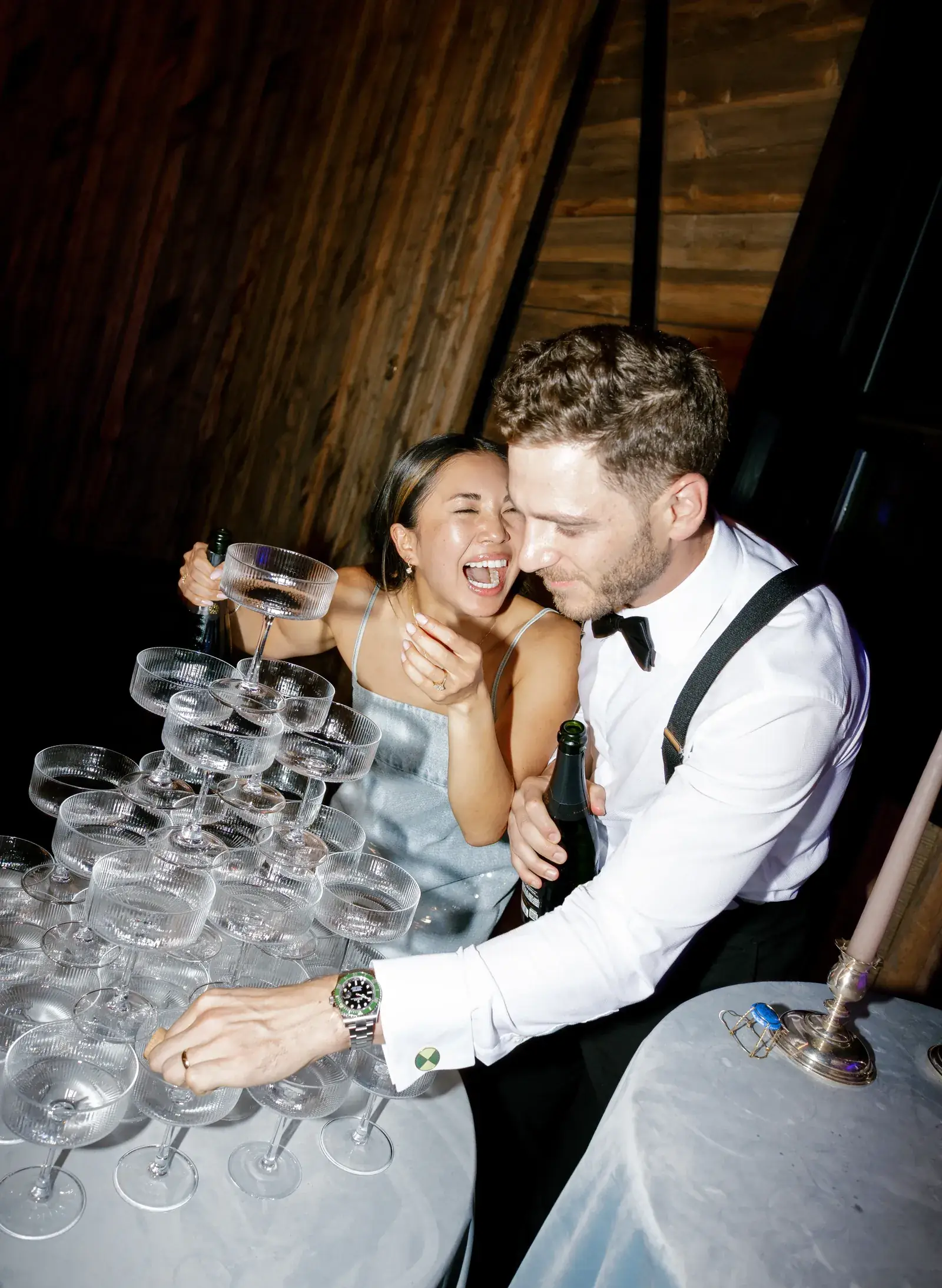 Bride and groom pouring champagne over a coupe tower at their reception
