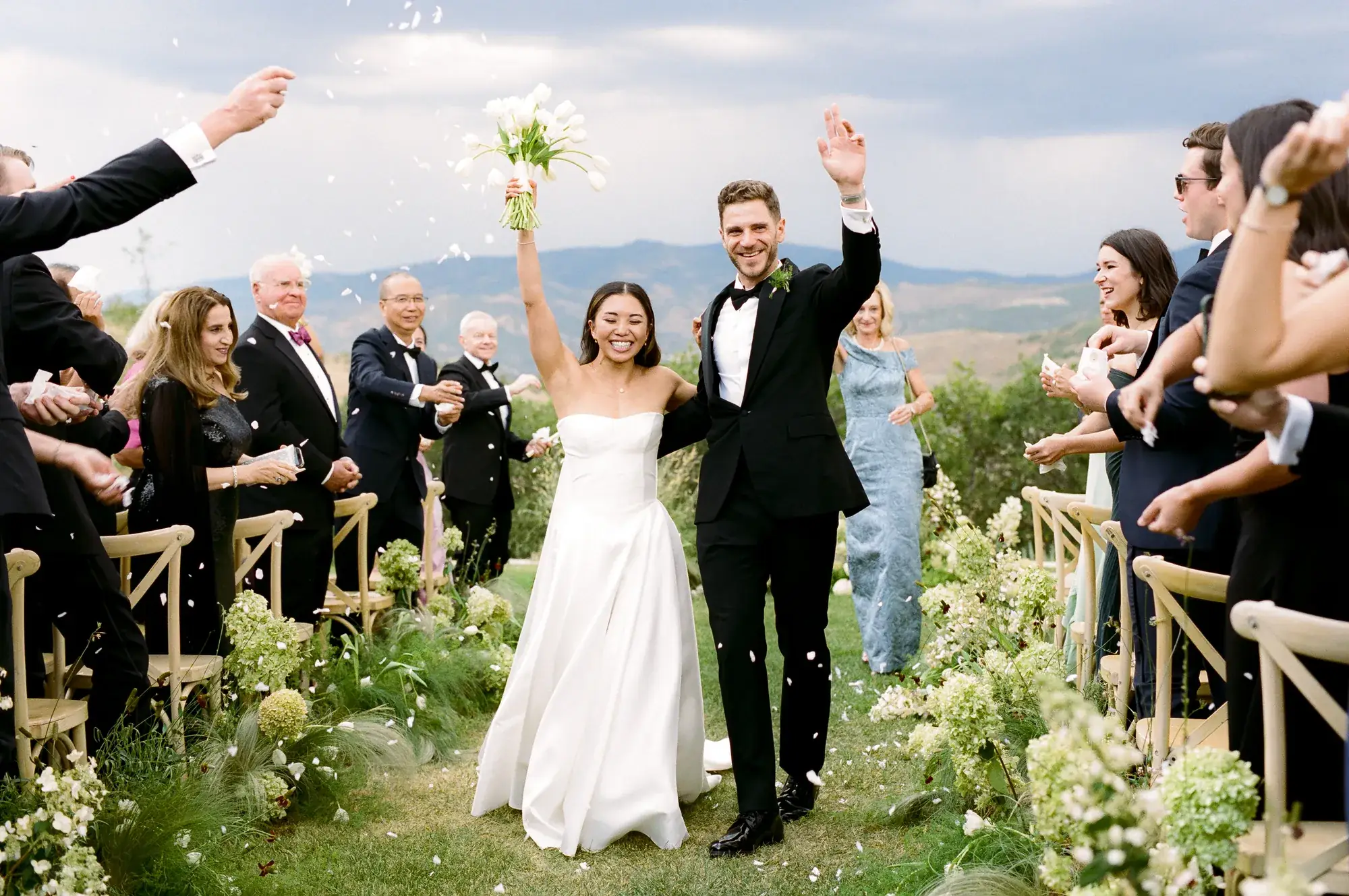 Petal toss celebration after an outdoor mountain wedding ceremony